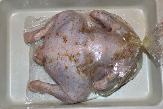 Помещаем куриную тушку в пакет и завязываем