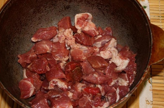 Первым слоем на дно выкладываем замаринованное мясо